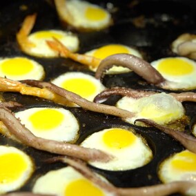 Fried quail eggs with squid tentacles and prawns